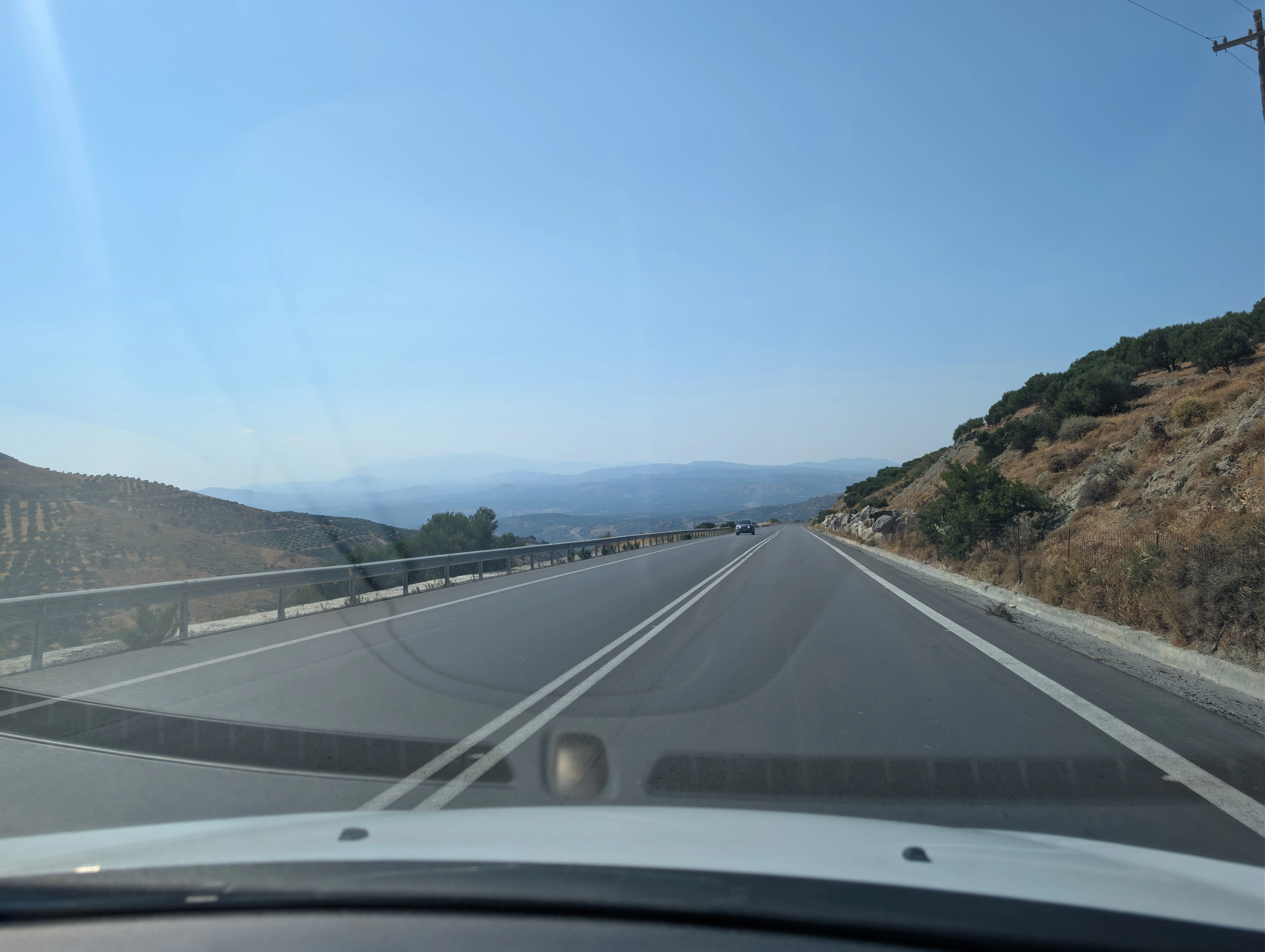 Blick durch die Windschutzscheibe auf eine Schnellstraße durch die Berge Kretas