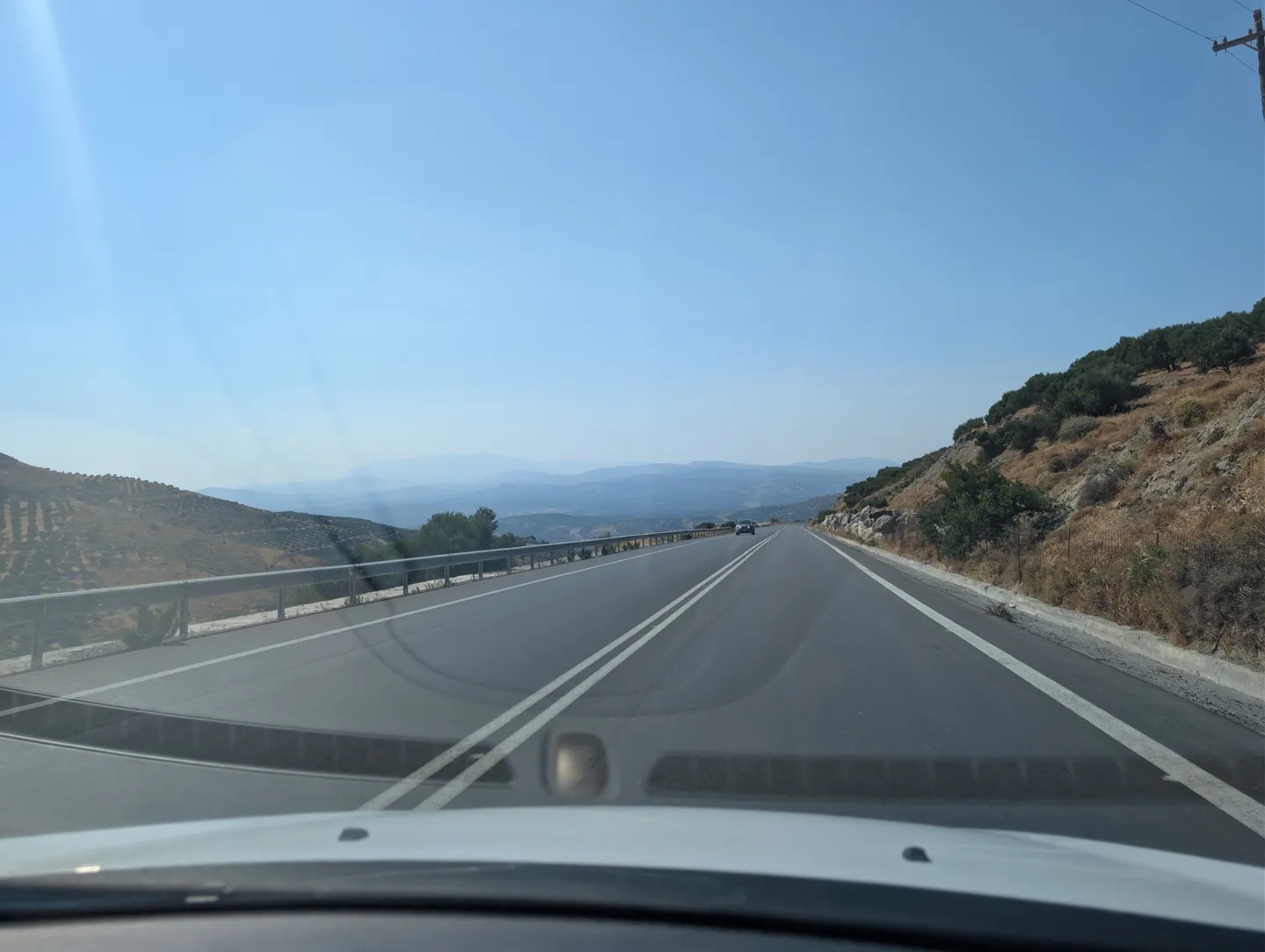 Blick durch die Windschutzscheibe auf eine Schnellstraße durch die Berge Kretas
