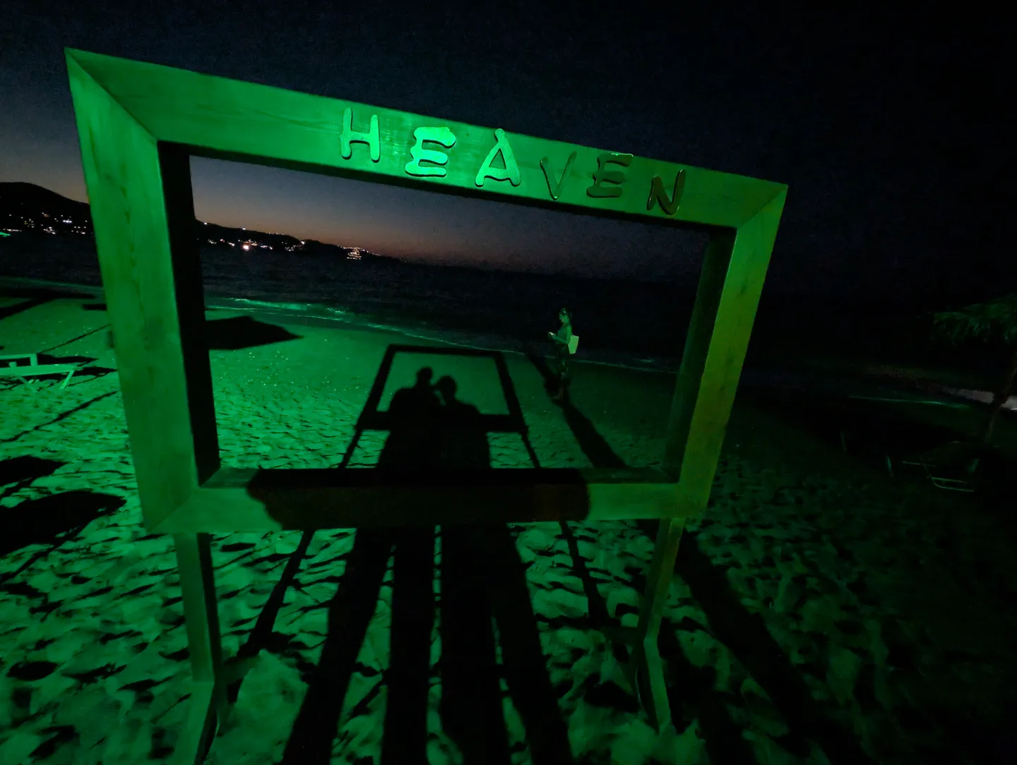 Beleuchteter Bilderrahmen mit dem Schriftzug Heaven am nächtlichen Strand