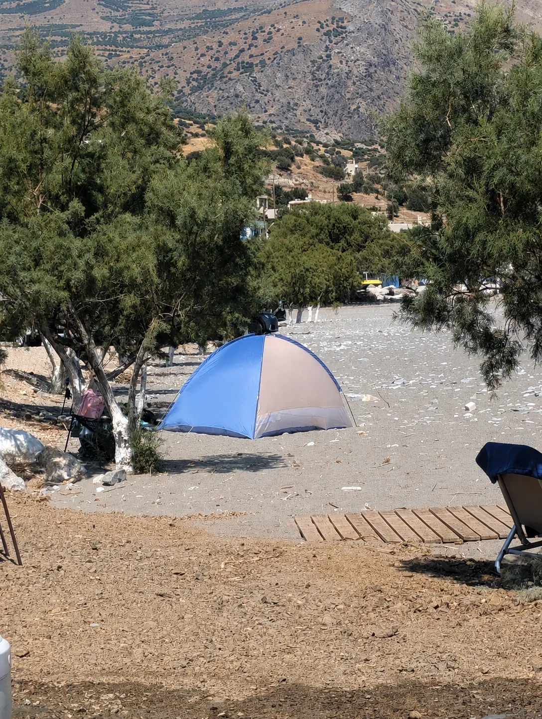 Strandmuschel und Liegen unter Tamarisken am Kastri Strand vor den Bergen Südkretas