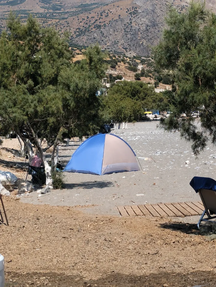 Strandmuschel und Liegen unter Tamarisken am Kastri Strand vor den Bergen Südkretas