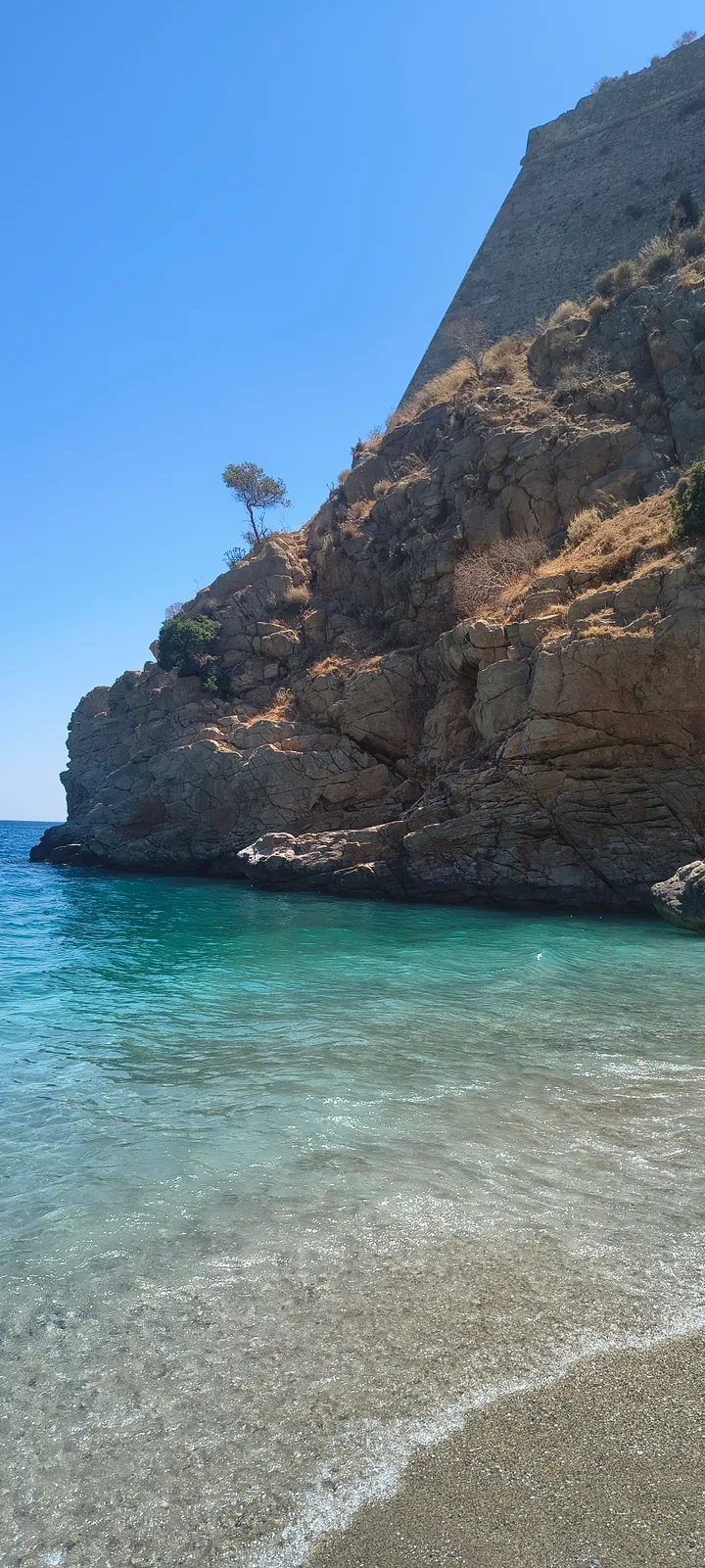 Steile Felswand über dem türkisfarbenen Wasser am Paralia Paleokastro Strand